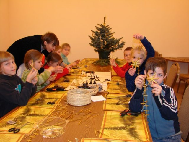 Rotā Ziemassvētku eglīte ar salmu rotaļlietām